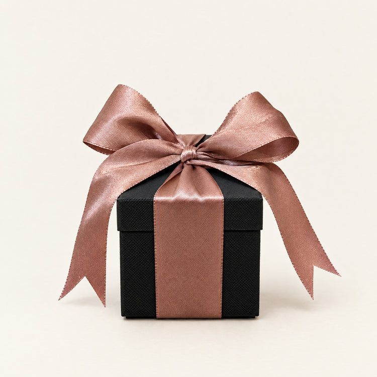Small matte black gift box tied with a satin ribbon and bow