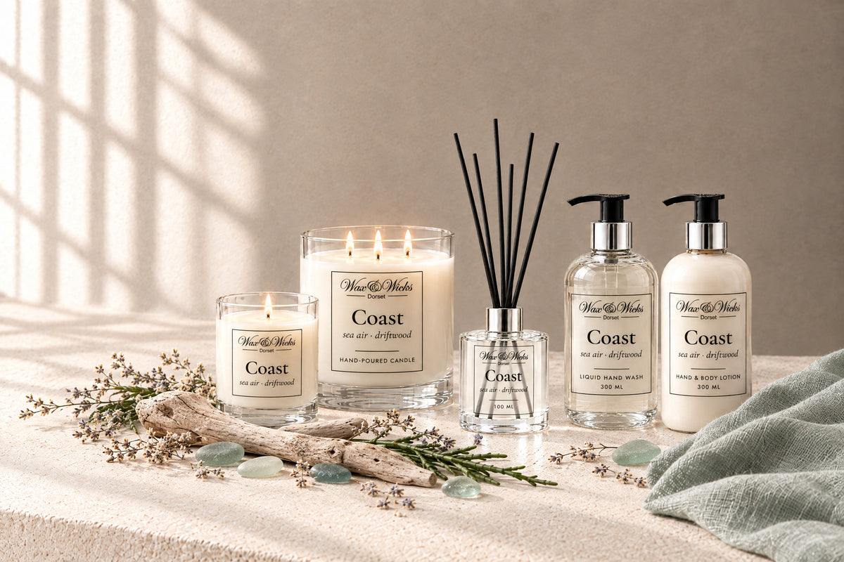 Coast small and large candles, reed diffuser, hand wash and hand & body lotion together, styled with bleached driftwood, sea-glass pebbles, dried sea lavender and samphire