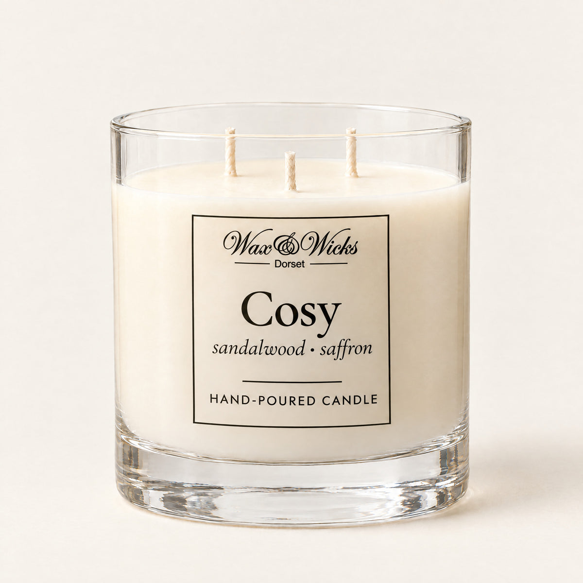 Large Cosy candle, three wicks, in a clear glass jar, on a plain ivory background