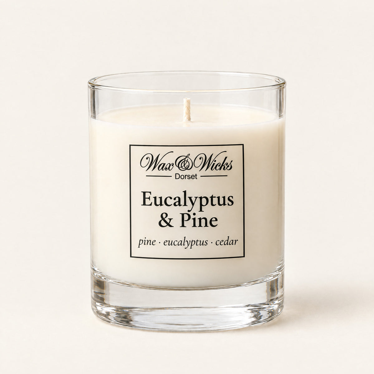 Small Eucalyptus & Pine candle, one wick, in a clear glass jar, on a plain ivory background