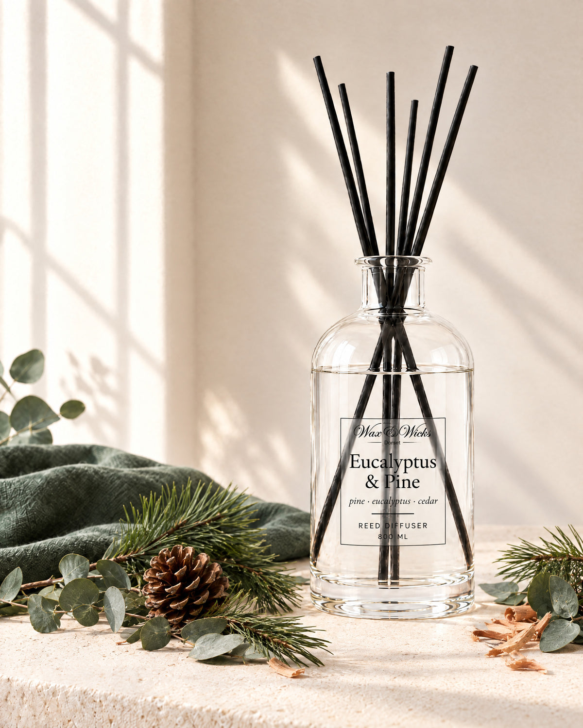 Eucalyptus & Pine 800 ml large reed diffuser in apothecary-style glass with extra-long reeds, styled with eucalyptus stems, pine sprigs, a pine cone and cedar shavings