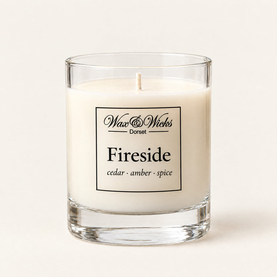 Small Fireside candle, one wick, in a clear glass jar, on a plain ivory background