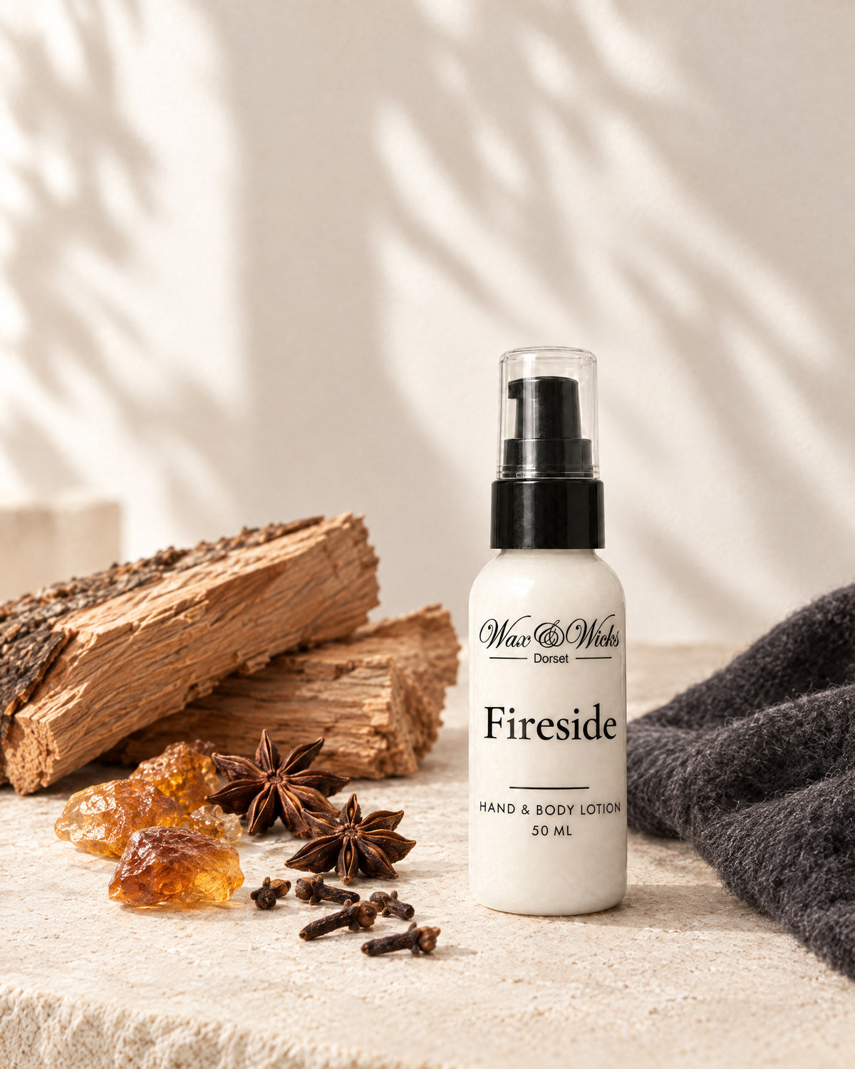 Fireside hand & body lotion, 50 ml bottle, styled with split cedar logs, amber resin and whole spices
