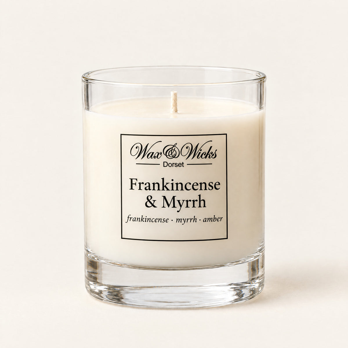 Small Frankincense & Myrrh candle, one wick, in a clear glass jar, on a plain ivory background