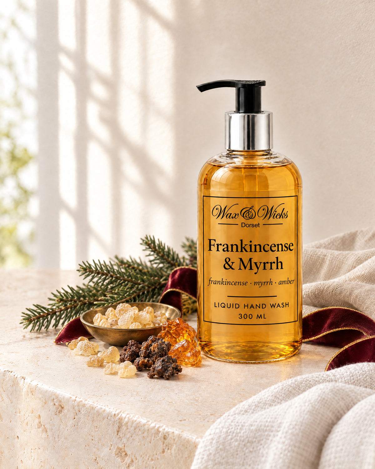 Frankincense & Myrrh liquid hand wash, 300 ml pump bottle, styled with frankincense and myrrh resin, a fir sprig and burgundy ribbon