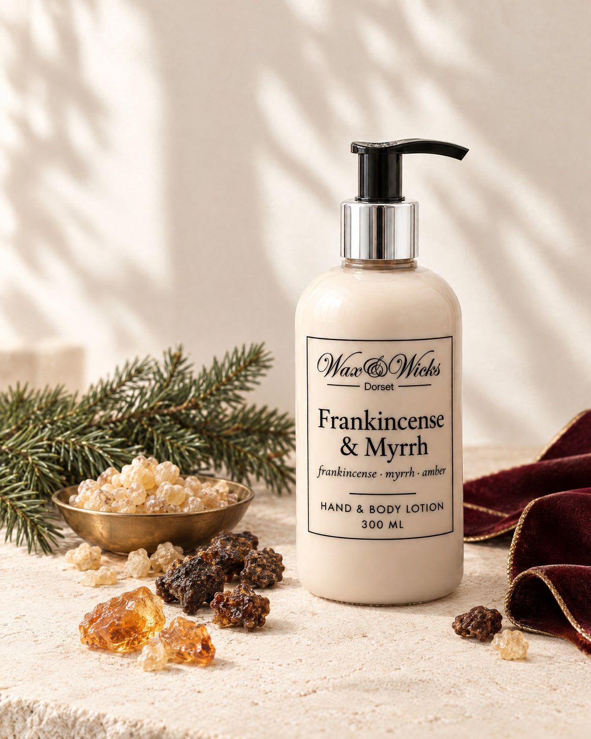 Frankincense & Myrrh hand & body lotion, 300 ml pump bottle, styled with frankincense and myrrh resin, a fir sprig and burgundy ribbon