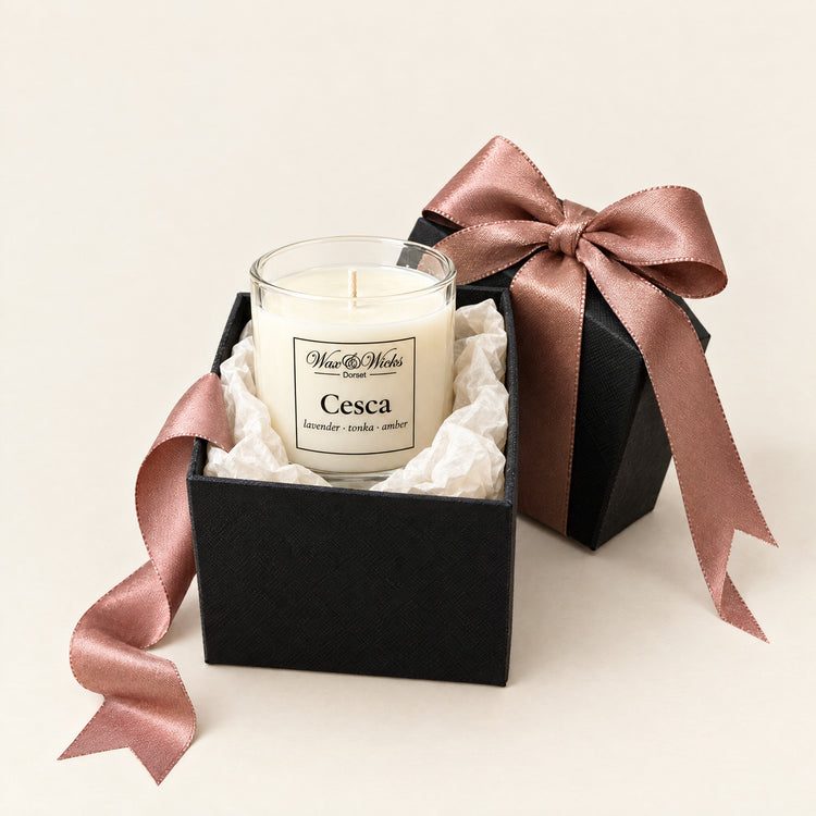 Small gift box open, with a small Cesca candle sitting in white tissue inside