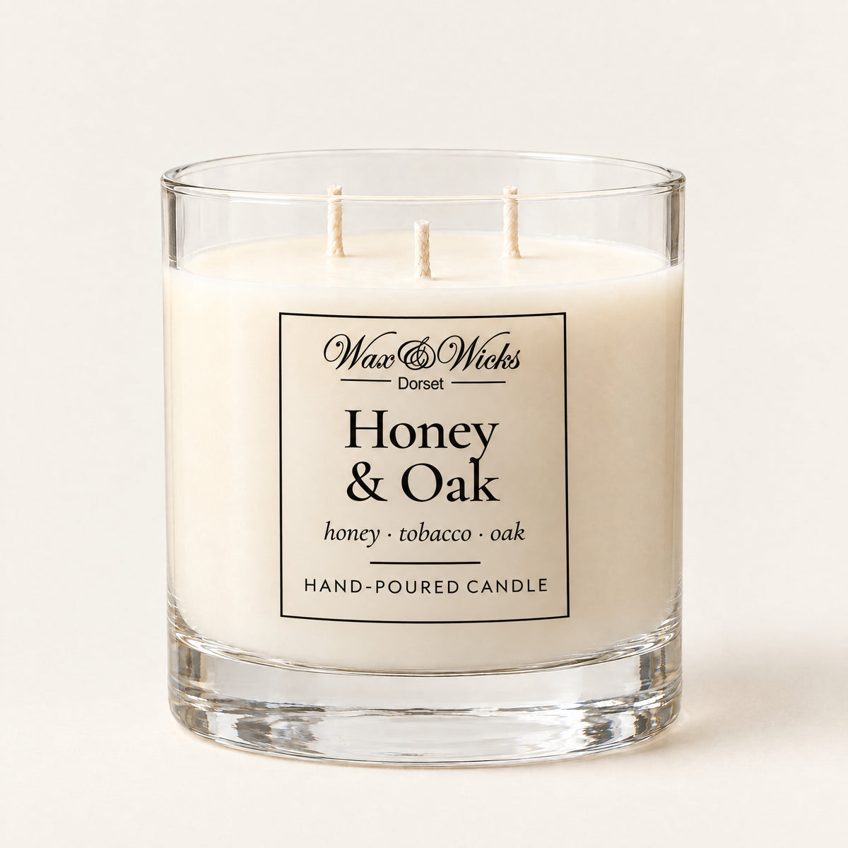Large Honey & Oak candle, three wicks, in a clear glass jar, on a plain ivory background