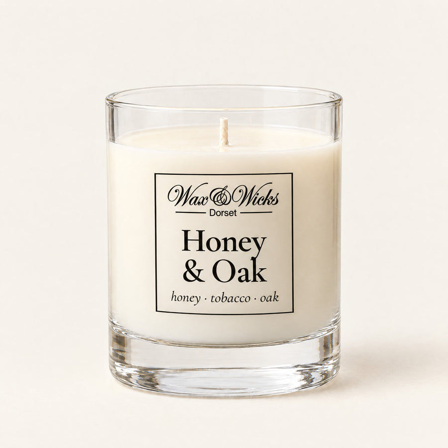 Small Honey & Oak candle, one wick, in a clear glass jar, on a plain ivory background