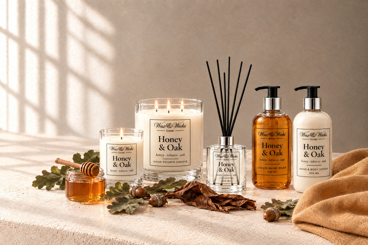 Honey & Oak candles and home fragrance together, styled with a jar of honey, oak leaves, acorns and tobacco leaf