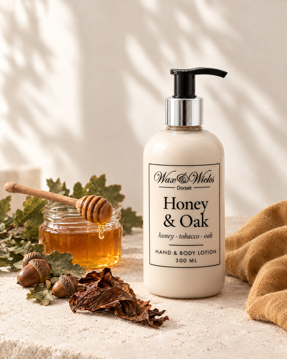 Honey & Oak hand & body lotion, 300 ml pump bottle, styled with a jar of honey, oak leaves, acorns and tobacco leaf