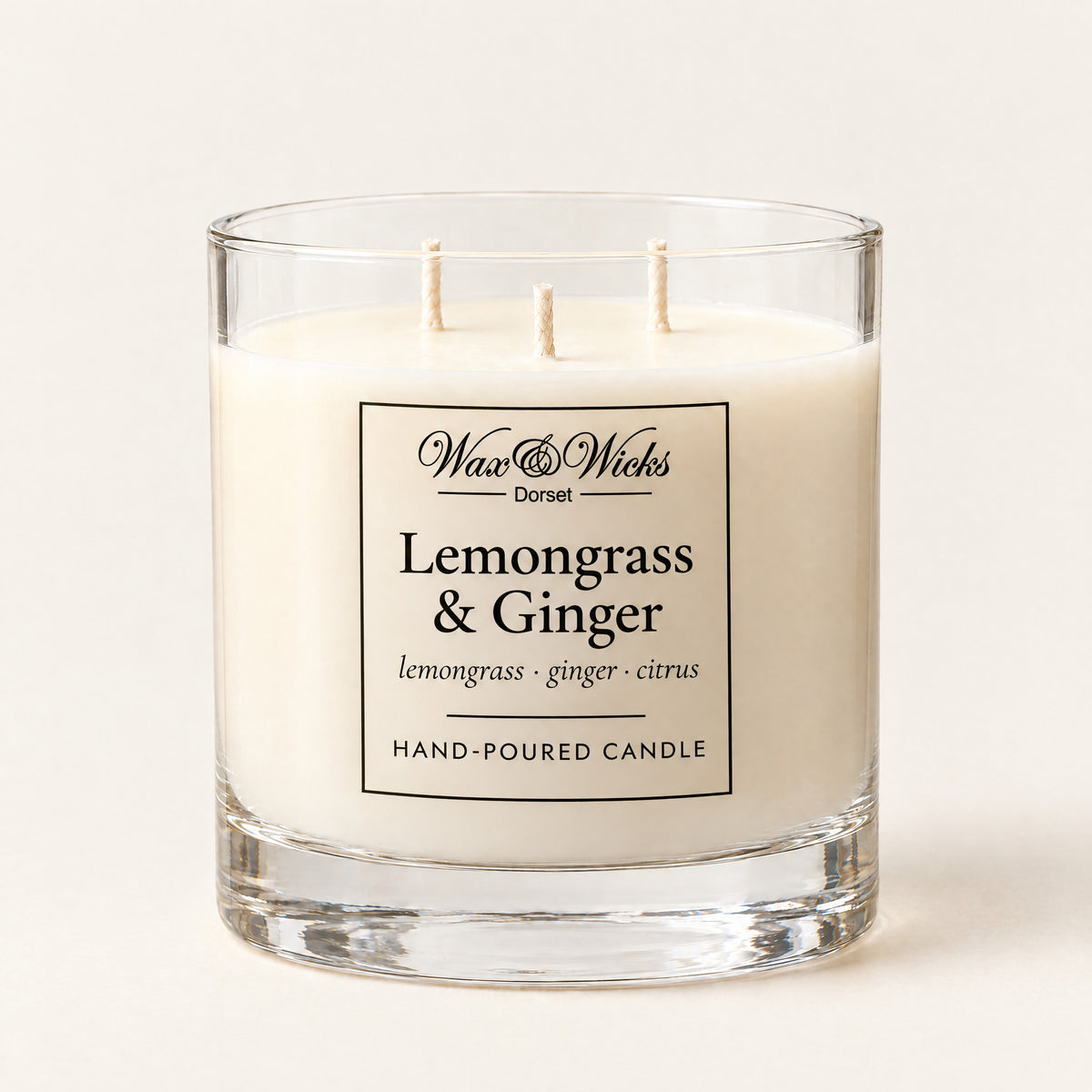 Large Lemongrass & Ginger candle, three wicks, in a clear glass jar, on a plain ivory background