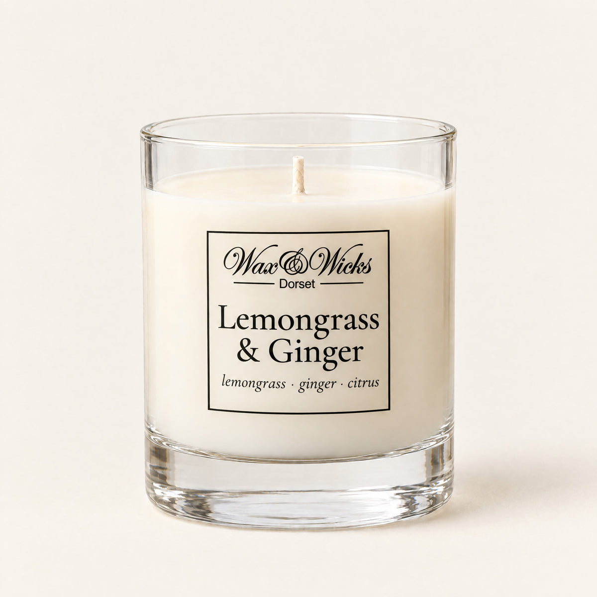 Small Lemongrass & Ginger candle, one wick, in a clear glass jar, on a plain ivory background