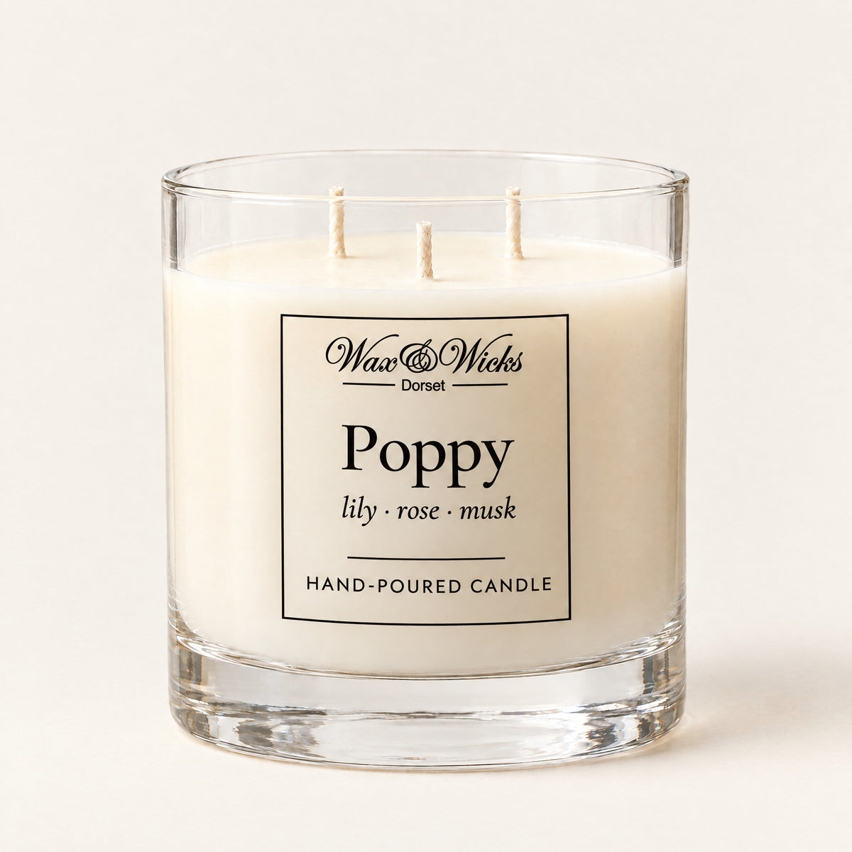 Large Poppy candle, three wicks, in a clear glass jar, on a plain ivory background