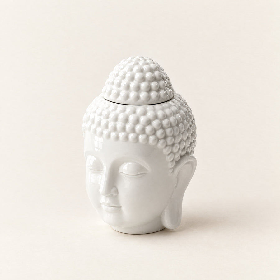 Prince Buddha wax melt burner in white ceramic, a Buddha head with a top-knot lid, on a plain ivory background