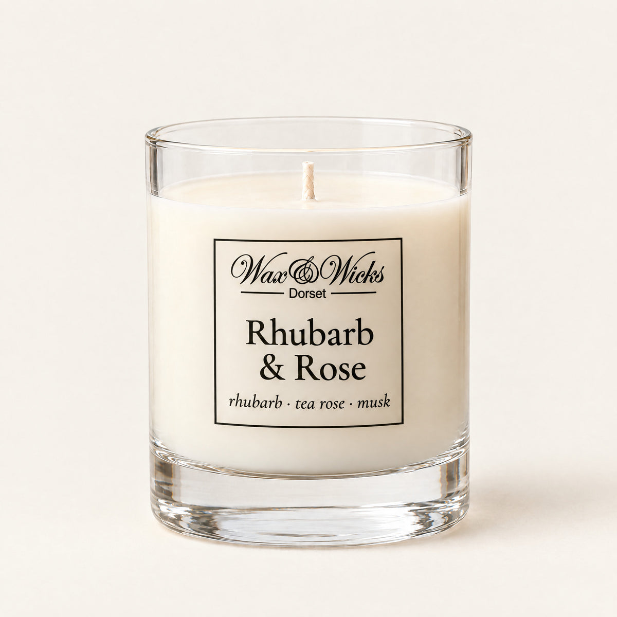 Small Rhubarb & Rose candle, one wick, in a clear glass jar, on a plain ivory background