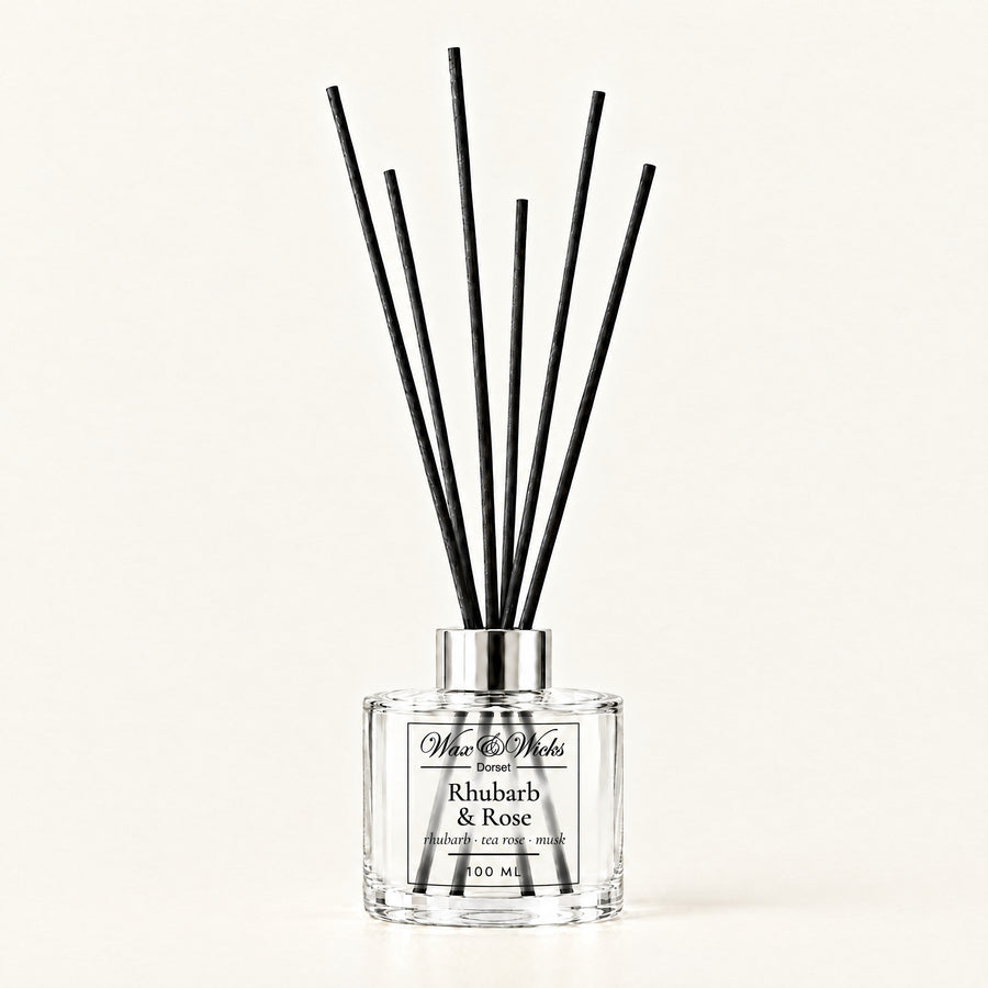 Rhubarb & Rose 100 ml reed diffuser with black fibre reeds, on a plain ivory background