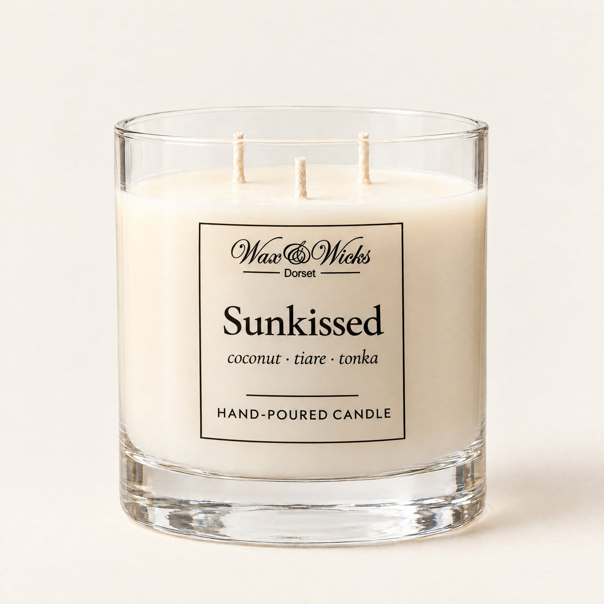 Large Sunkissed candle, three wicks, in a clear glass jar, on a plain ivory background