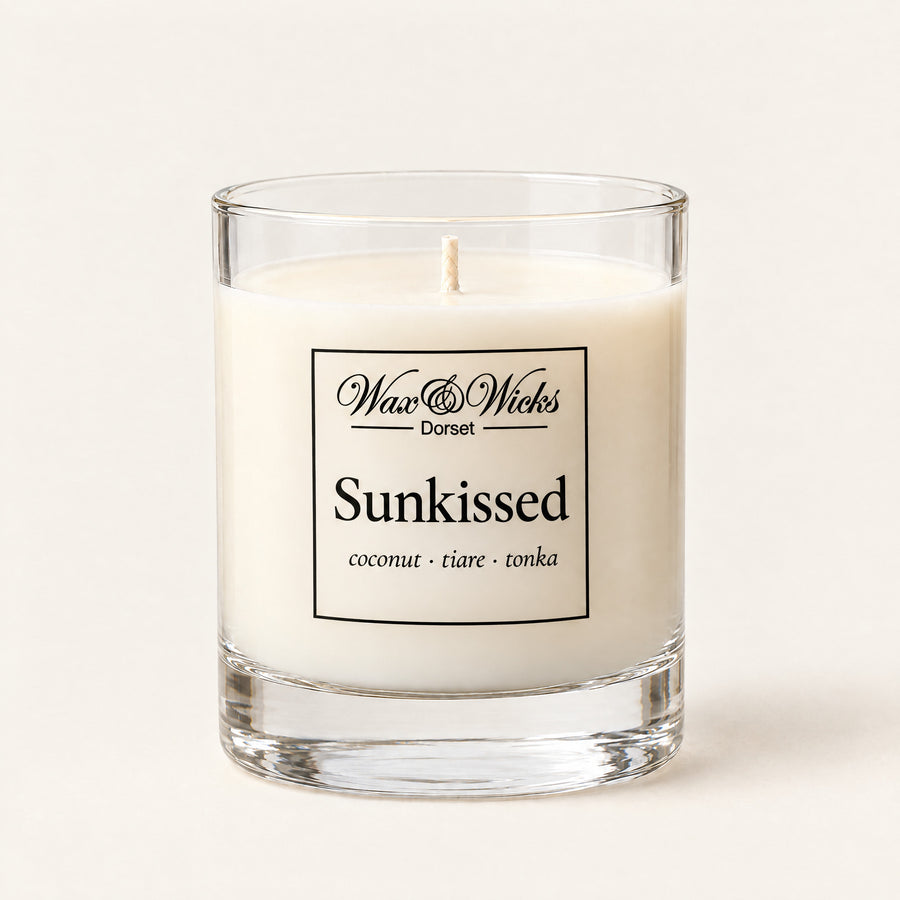 Small Sunkissed candle, one wick, in a clear glass jar, on a plain ivory background
