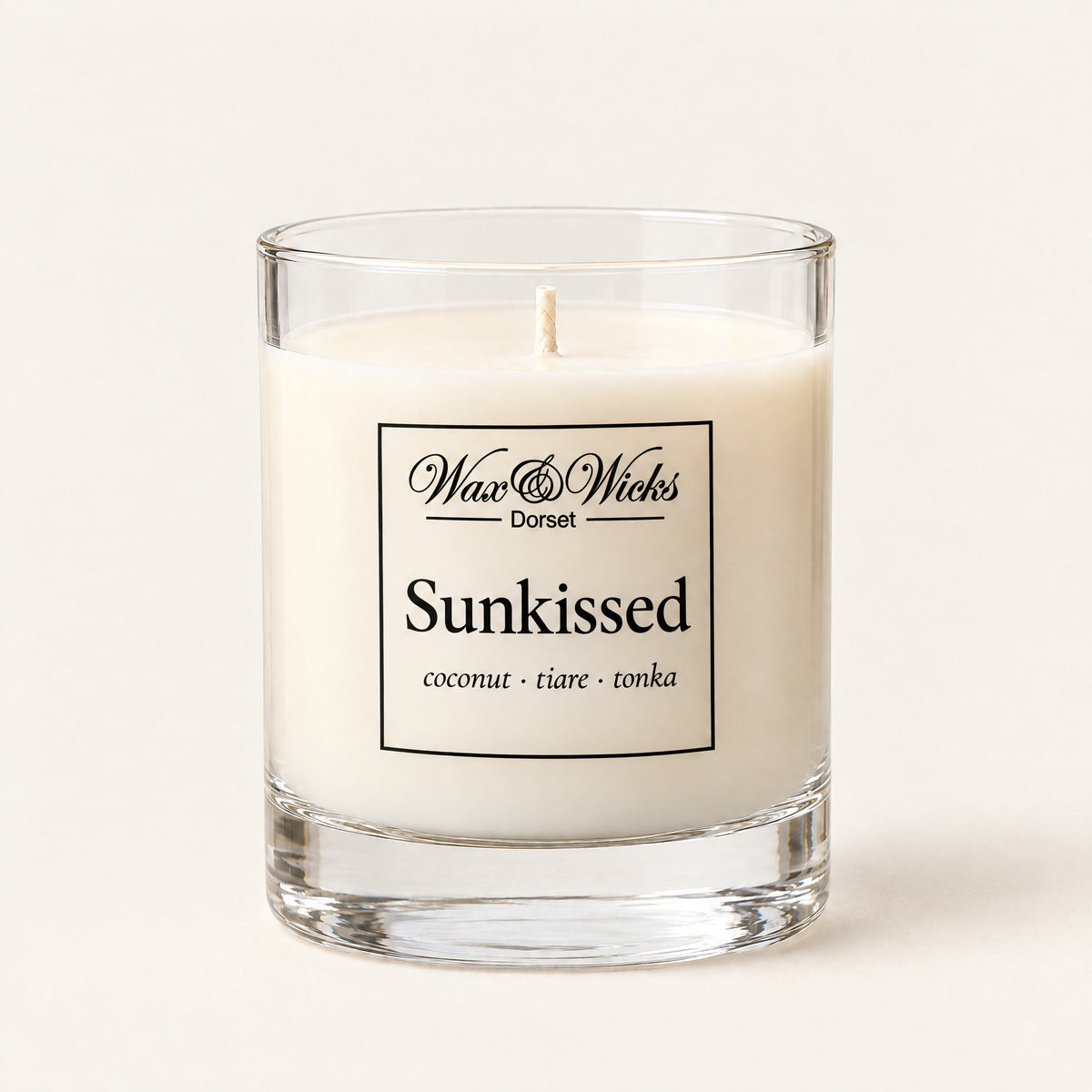 Small Sunkissed candle, one wick, in a clear glass jar, on a plain ivory background