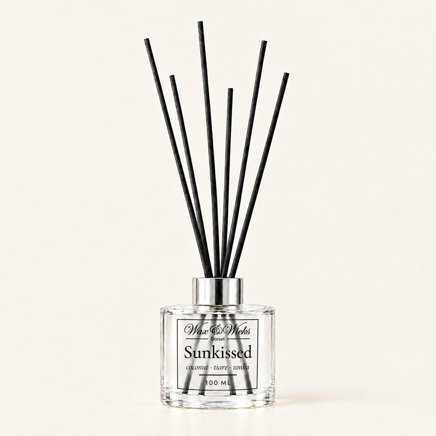 Sunkissed 100 ml reed diffuser with black fibre reeds, on a plain ivory background