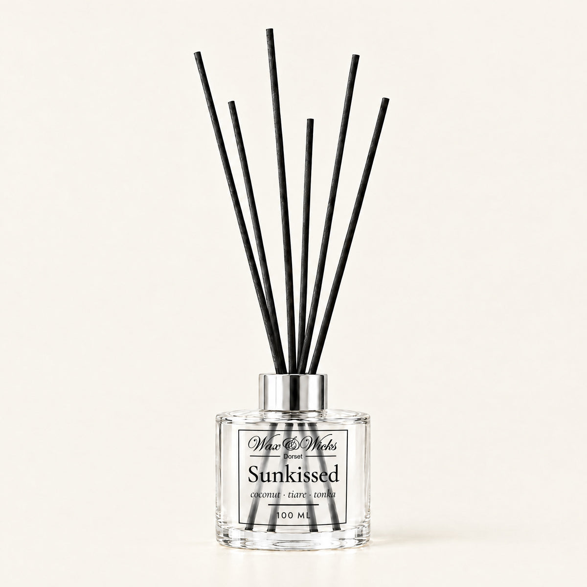 Sunkissed 100 ml reed diffuser with black fibre reeds, on a plain ivory background