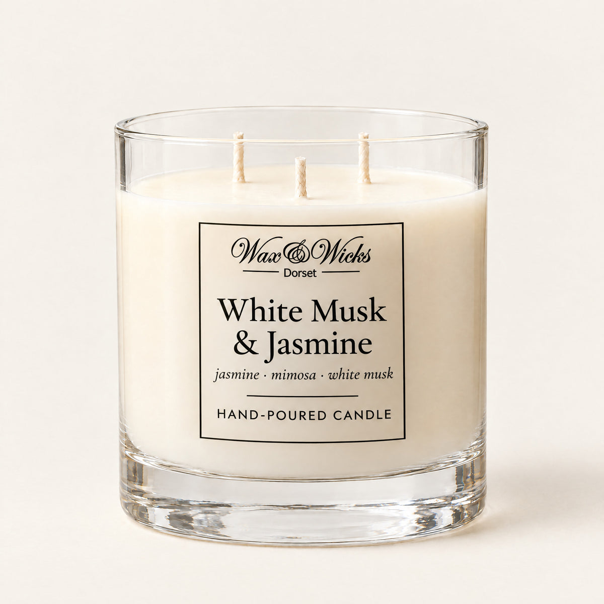 Large White Musk & Jasmine candle, three wicks, in a clear glass jar, on a plain ivory background