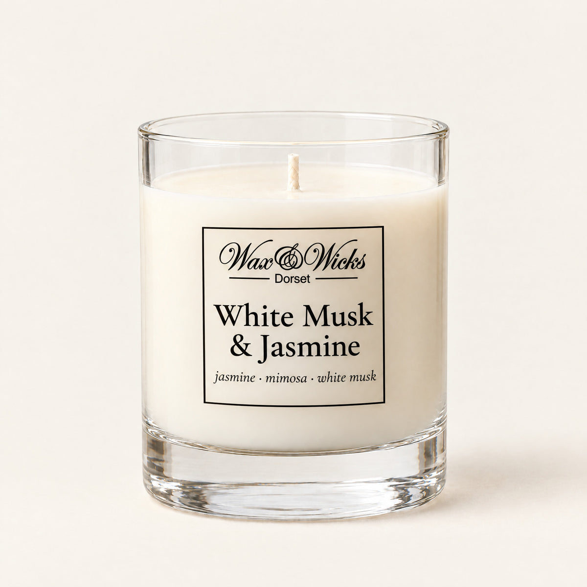 Small White Musk & Jasmine candle, one wick, in a clear glass jar, on a plain ivory background