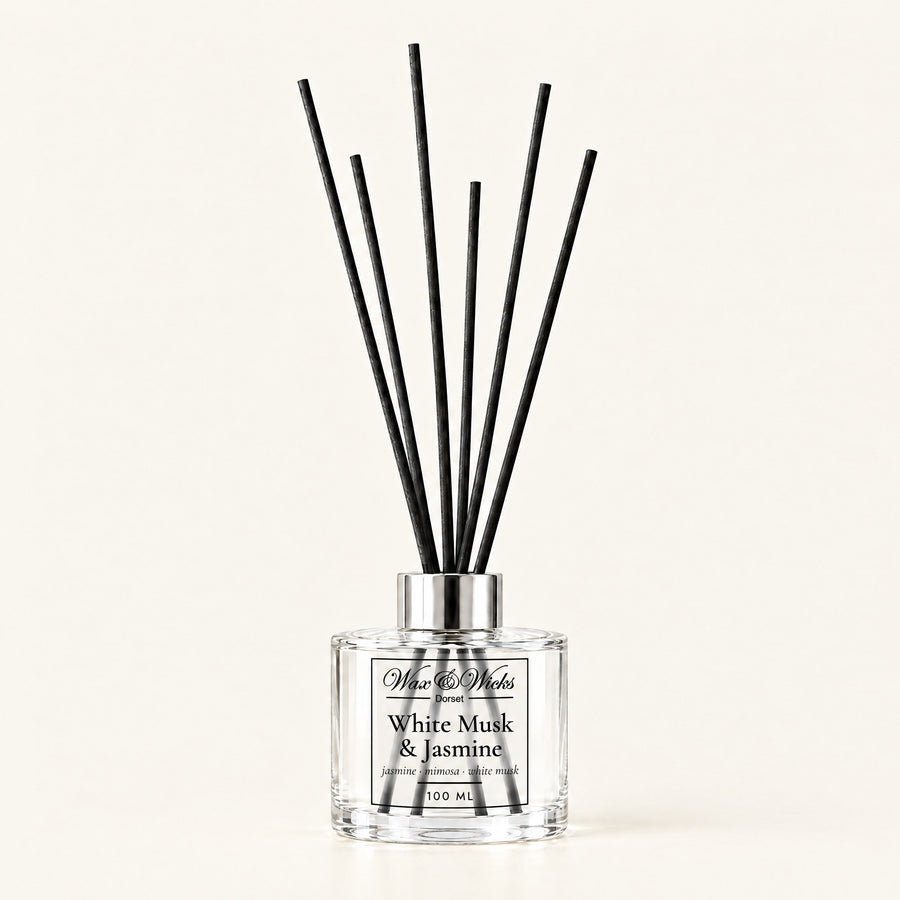 White Musk & Jasmine 100 ml reed diffuser with black fibre reeds, on a plain ivory background