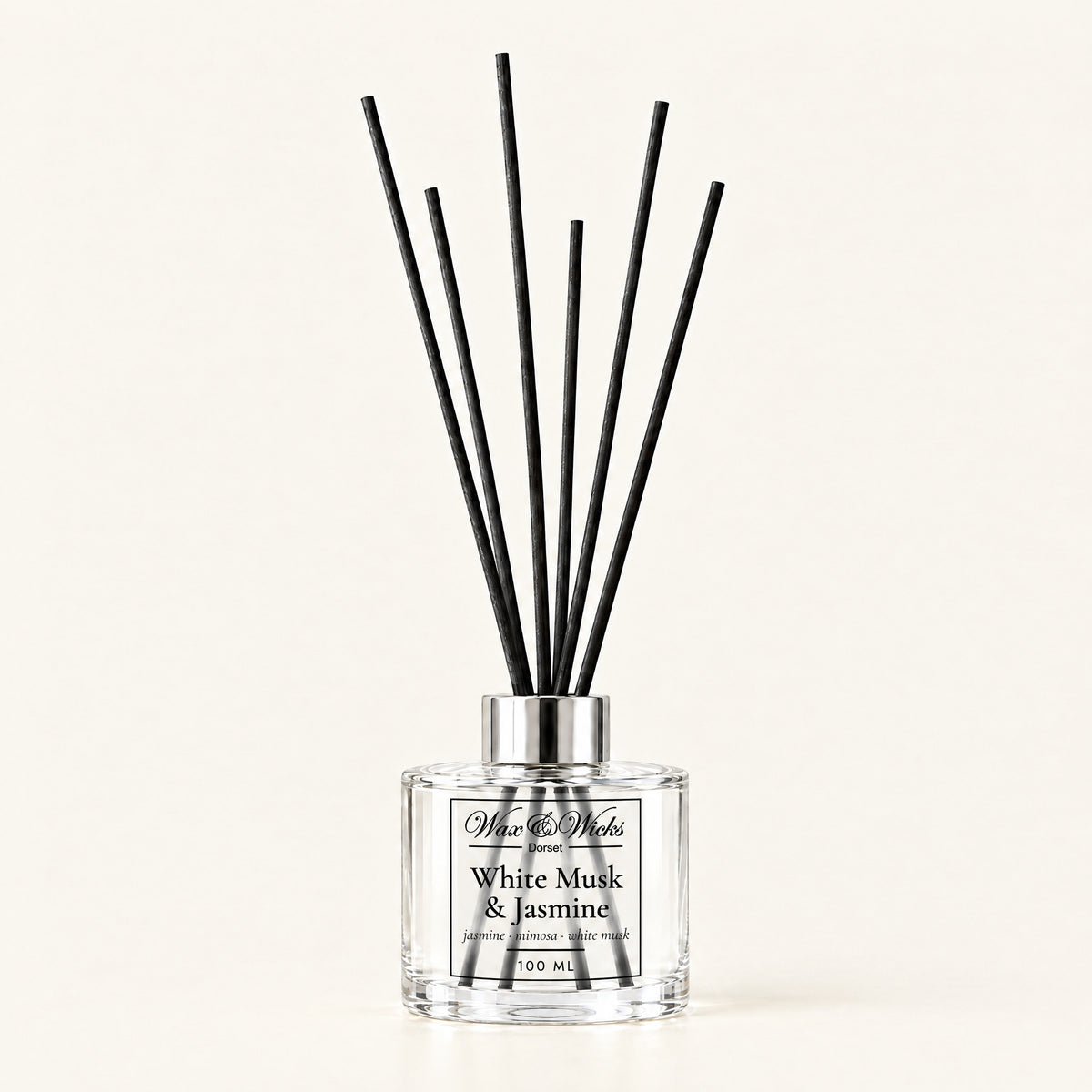 White Musk & Jasmine 100 ml reed diffuser with black fibre reeds, on a plain ivory background