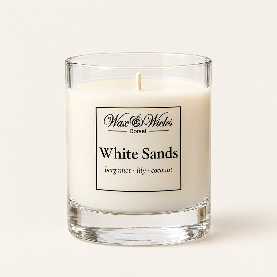 Small White Sands candle, one wick, in a clear glass jar, on a plain ivory background