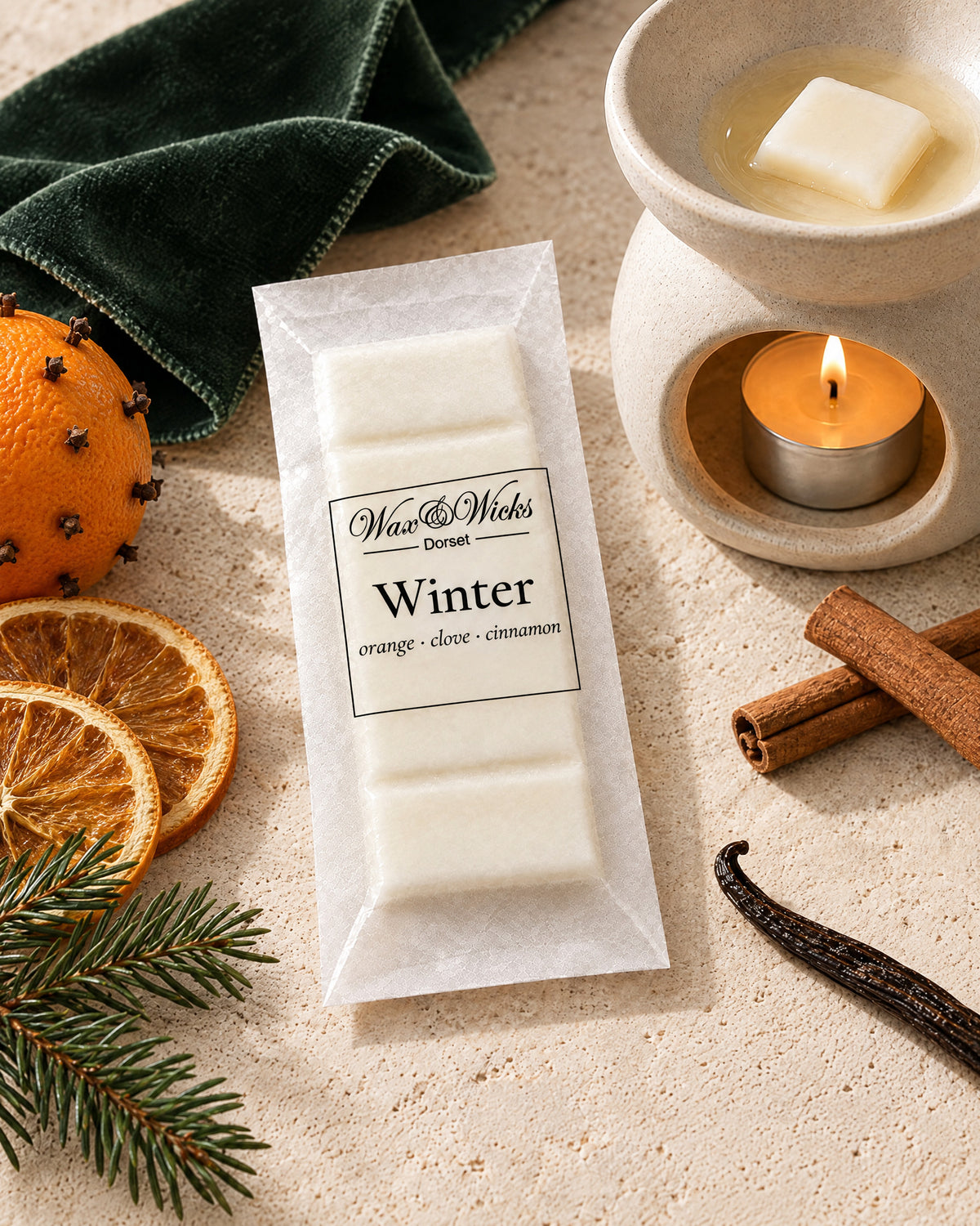 Winter wax melt snap bar, styled with a clove-studded orange, dried orange slices, cinnamon sticks and fir